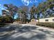 Tan mobile home with a deck and surrounding landscaping at 3234 Ella Ln, New Port Richey, FL 34655