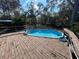 Above ground pool with wooden deck and surrounding trees at 3234 Ella Ln, New Port Richey, FL 34655