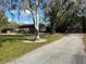 Property with multiple storage sheds and a gravel driveway at 3234 Ella Ln, New Port Richey, FL 34655
