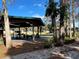 Spacious backyard with mature trees and a covered patio at 3234 Ella Ln, New Port Richey, FL 34655
