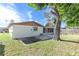View of the home's backyard with a large tree and fenced area at 3337 Darlington Rd, Holiday, FL 34691