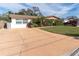 Front view of a house with a spacious driveway and landscaping at 3337 Darlington Rd, Holiday, FL 34691