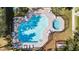 Aerial view of a community pool with lounge chairs and a spa at 6334 Timberly Ln, Zephyrhills, FL 33542