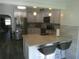 Modern kitchen features stainless steel appliances and an island with seating at 641 Wilkie St, Dunedin, FL 34698