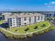 Aerial view of waterfront condo building with lush landscaping and parking at 8150 Brent St # 746, Port Richey, FL 34668