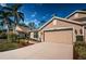 Tan house with two-car garage and landscaping at 9609 Brookdale Dr, New Port Richey, FL 34655