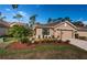 Tan house with two-car garage and landscaping at 9609 Brookdale Dr, New Port Richey, FL 34655