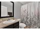Clean bathroom with a floral shower curtain and dark vanity at 10724 Burning Bush Ter, Land O Lakes, FL 34638