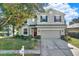 Two-story house with a green exterior, red door, and attached garage at 10724 Burning Bush Ter, Land O Lakes, FL 34638