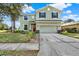 Two-story house with a green exterior, red door, and attached garage at 10724 Burning Bush Ter, Land O Lakes, FL 34638