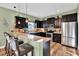 U-shaped kitchen with dark cabinets, granite countertops, and stainless steel appliances at 10724 Burning Bush Ter, Land O Lakes, FL 34638