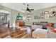 Living room with hardwood floors, L-shaped sofa, and a wall gallery at 10724 Burning Bush Ter, Land O Lakes, FL 34638