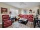 Cozy living room with red couch, wood floors, and a large window at 11617 Boynton Ln, New Port Richey, FL 34654