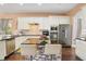 Spacious kitchen with white cabinets, granite island, and stainless steel appliances at 13455 Niti Dr, Hudson, FL 34669