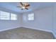 Bedroom with two windows, ceiling fan and tile floors at 13541 Stacey Dr, Hudson, FL 34667