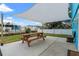 Concrete patio with shaded picnic table and partial waterfront view at 13822 Judy Ave, Hudson, FL 34667