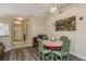 Charming dining area with gray wood floors, adjacent to the entryway, and decorative art at 14120 Whitecap Ave, Hudson, FL 34667