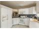 White kitchen with updated countertops and tile backsplash at 14120 Whitecap Ave, Hudson, FL 34667