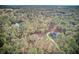 Aerial view of a house on a wooded lot with a long driveway at 19478 Hidden Oaks Dr, Brooksville, FL 34604