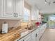 Long kitchen with white cabinets and granite countertops at 3340 Oleander Dr, Hernando Beach, FL 34607