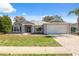 One-story house featuring gray exterior, a two-car garage, and well-maintained lawn at 3470 Cedar Crest Loop, Spring Hill, FL 34609
