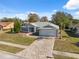 Single-story home with gray exterior and a paved driveway at 3470 Cedar Crest Loop, Spring Hill, FL 34609