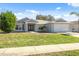 Single-story home with gray exterior, double door entry and paved driveway at 3470 Cedar Crest Loop, Spring Hill, FL 34609