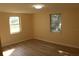 Well-lit bedroom with two windows and wood-look floors at 3518 Moog Rd, Holiday, FL 34691