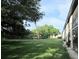 Landscaped backyard with green grass and mature trees at 4829 Onyx Ln # 102, New Port Richey, FL 34652