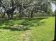 Spacious backyard with lush green grass and mature trees providing shade at 4829 Onyx Ln # 102, New Port Richey, FL 34652