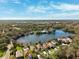Aerial view showcases waterfront homes, lush landscaping, and a picturesque lake at 4886 Westchester Ct, Oldsmar, FL 34677