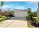 Front view of a tan house with a white garage door at 4886 Westchester Ct, Oldsmar, FL 34677