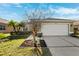 Tan house with white garage door and landscaping at 4886 Westchester Ct, Oldsmar, FL 34677