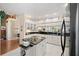 Bright kitchen featuring white cabinetry, dark countertops, and stainless steel appliances, seamlessly connecting to the adjacent living areas at 4886 Westchester Ct, Oldsmar, FL 34677