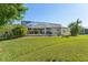 Landscaped backyard with pool and screened enclosure at 7302 Melogold Cir, Land O Lakes, FL 34637