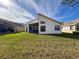 Home with spacious backyard, screened patio, and lush green grass at 9519 Green Needle Dr, New Port Richey, FL 34655