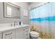 Bathroom with updated vanity and beach-themed shower curtain at 10620 Salamanca Dr, Port Richey, FL 34668