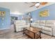 Spacious living room, featuring light gray reclining sofas and a ceiling fan at 10620 Salamanca Dr, Port Richey, FL 34668