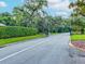 Gated entrance to Summertree with lush landscaping and a paved road at 11509 Sinatra Ct, New Port Richey, FL 34654