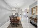 Bright dining room features a wood table with seating for six and view into kitchen at 11509 Sinatra Ct, New Port Richey, FL 34654