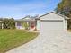 One-story home with gray siding, red door, and a paver driveway at 11509 Sinatra Ct, New Port Richey, FL 34654