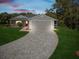 Attractive gray house with red door and landscaped yard at dusk at 11509 Sinatra Ct, New Port Richey, FL 34654