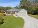 Gray house with red door, paved driveway, and landscaping at 11509 Sinatra Ct, New Port Richey, FL 34654