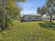 Home exterior showcasing a backyard with fire pit and screened patio at 11509 Sinatra Ct, New Port Richey, FL 34654