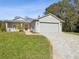 House exterior with paved driveway, landscaping, and front porch at 11509 Sinatra Ct, New Port Richey, FL 34654
