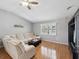 Spacious living room with hardwood floors, large windows, and sectional sofa at 11509 Sinatra Ct, New Port Richey, FL 34654