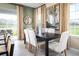 Elegant dining area with a dark wood table and neutral colored chairs at 12466 Amber Creek Cir, Lakewood Ranch, FL 34211