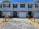 Two-story townhome with gray exterior, two-car garage, and landscaped front yard at 12466 Amber Creek Cir, Lakewood Ranch, FL 34211