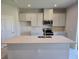 Modern kitchen with white cabinets, quartz countertops, and stainless steel appliances at 12466 Amber Creek Cir, Lakewood Ranch, FL 34211