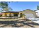 Tan house with a brown roof, arched windows, and a two-car garage at 1314 Vermont Ave, Tarpon Springs, FL 34689